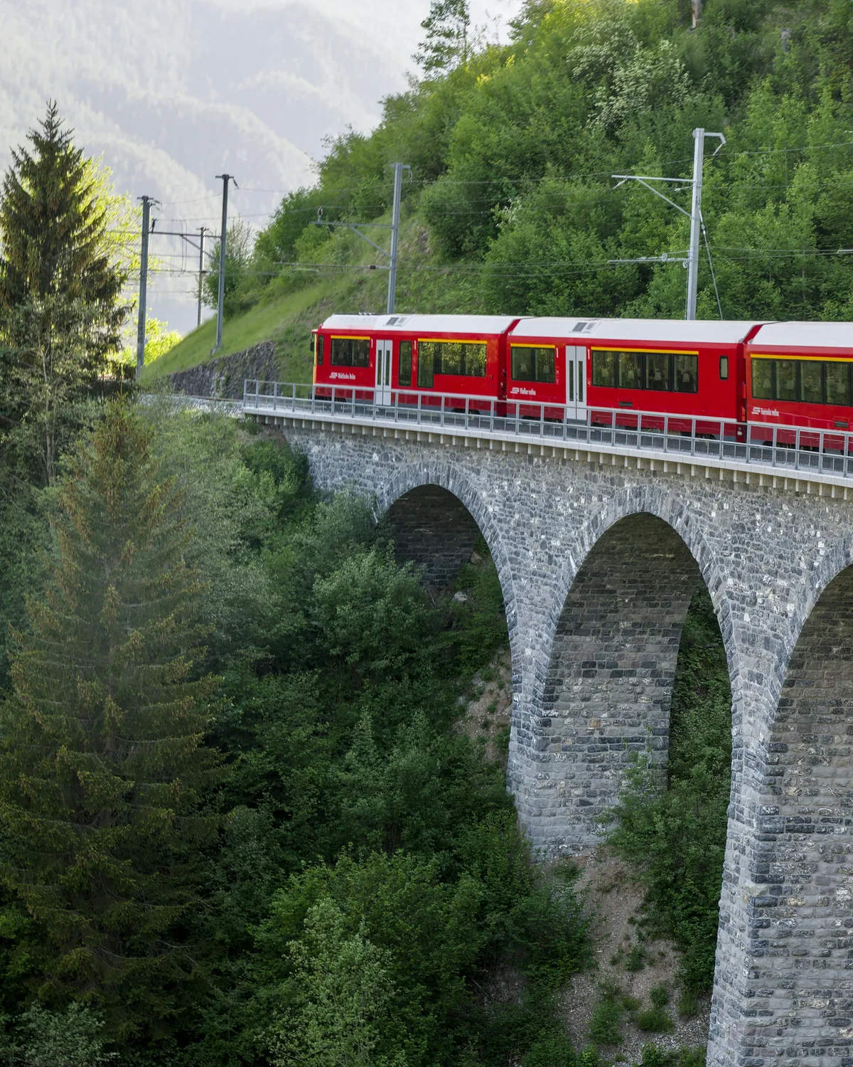 Red Bernina railway train above Lago Bianco near the Bernina Pass summit, the southern alpine crossing reached by day trips from Milan